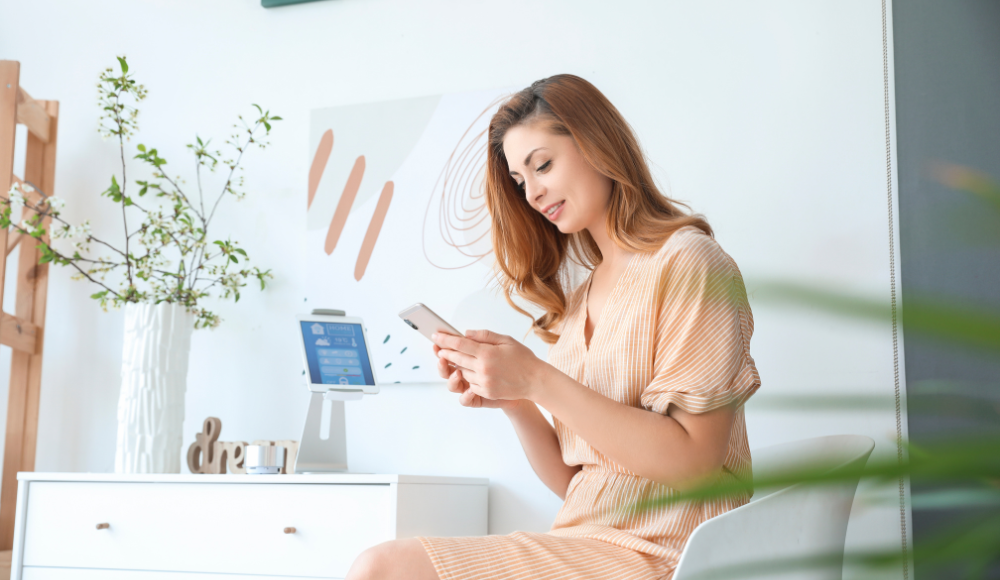 A woman sitting comfortably and checking her phone, highlighting the ease of leaving google reviews and engaging with businesses online.